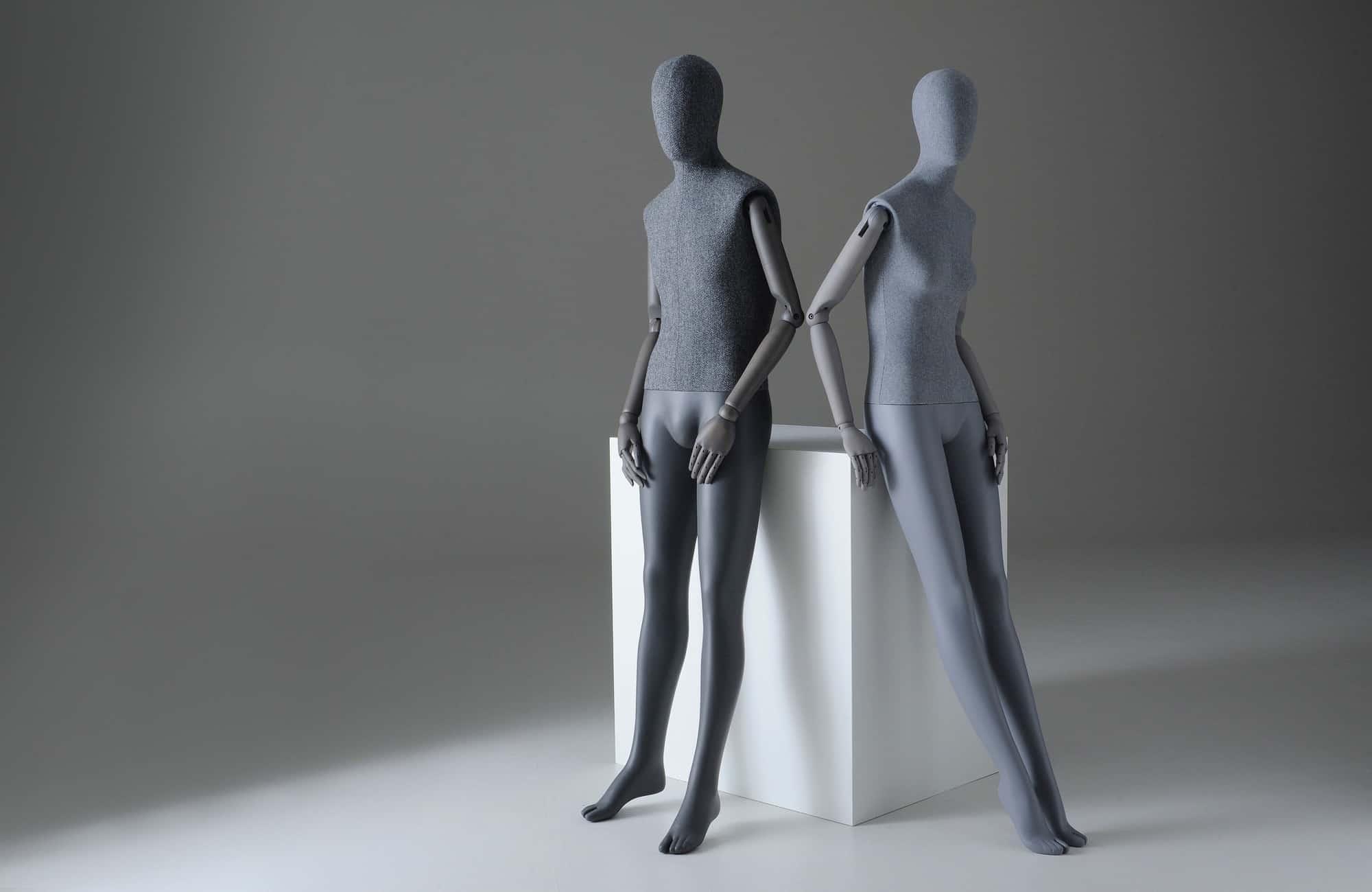 Male and female Sartorial mannequins leaning against a plinth