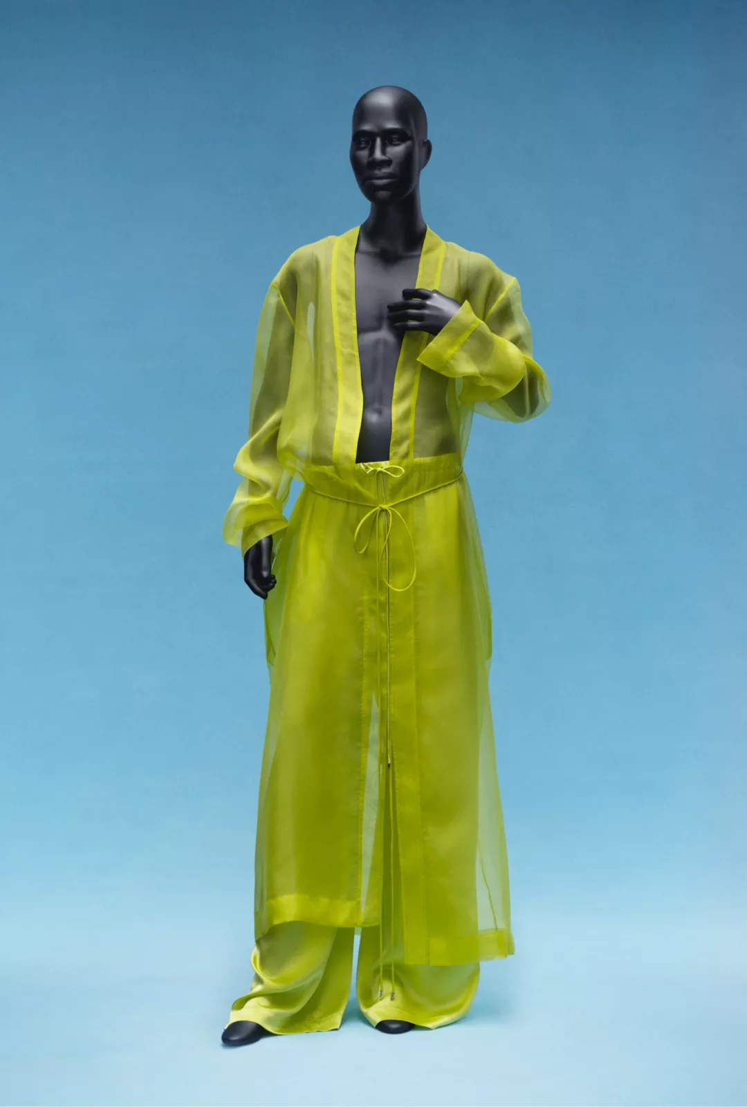 A mannequin dressed in a see-through yellow ensemble.