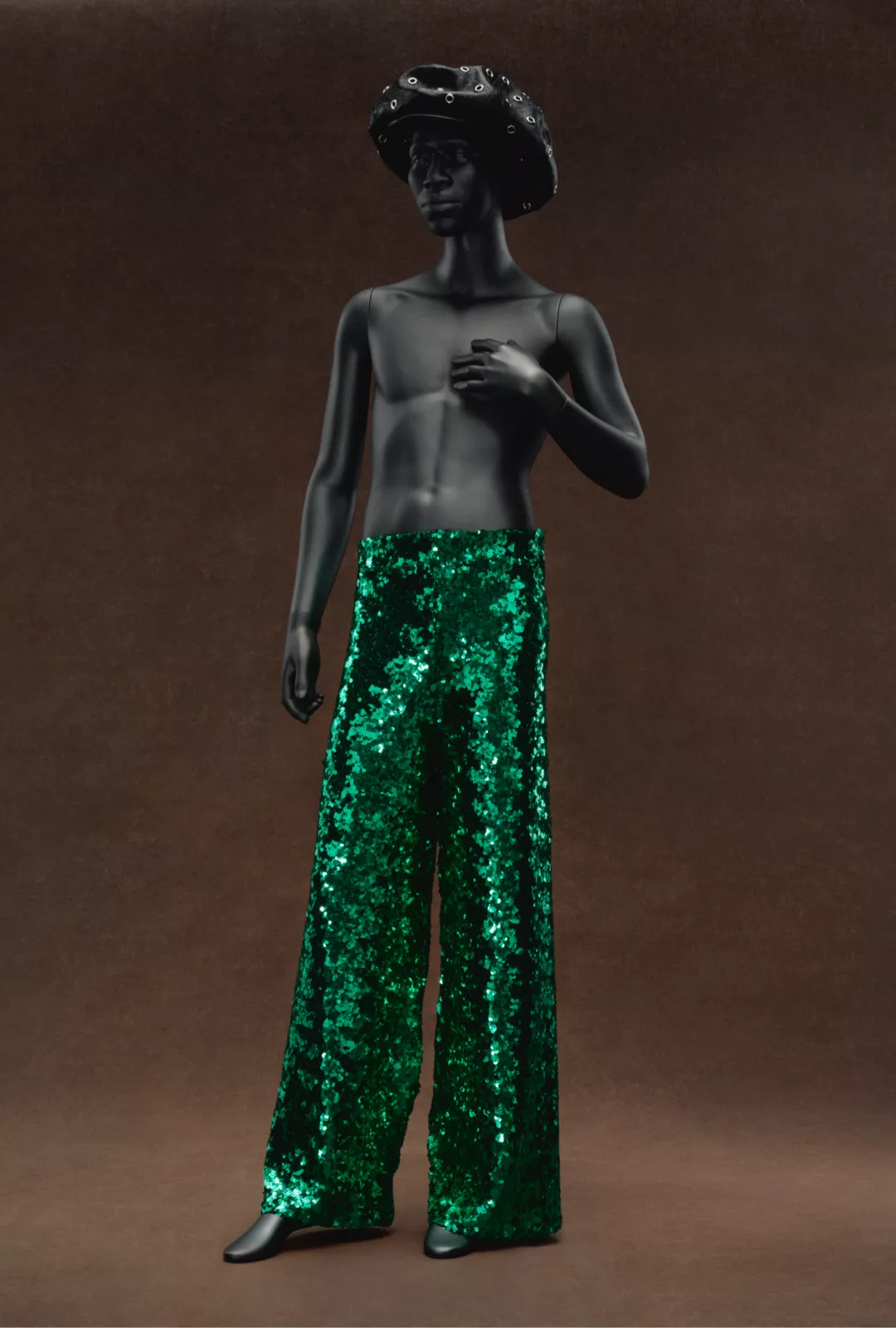 a mannequin with a hat and green trousers