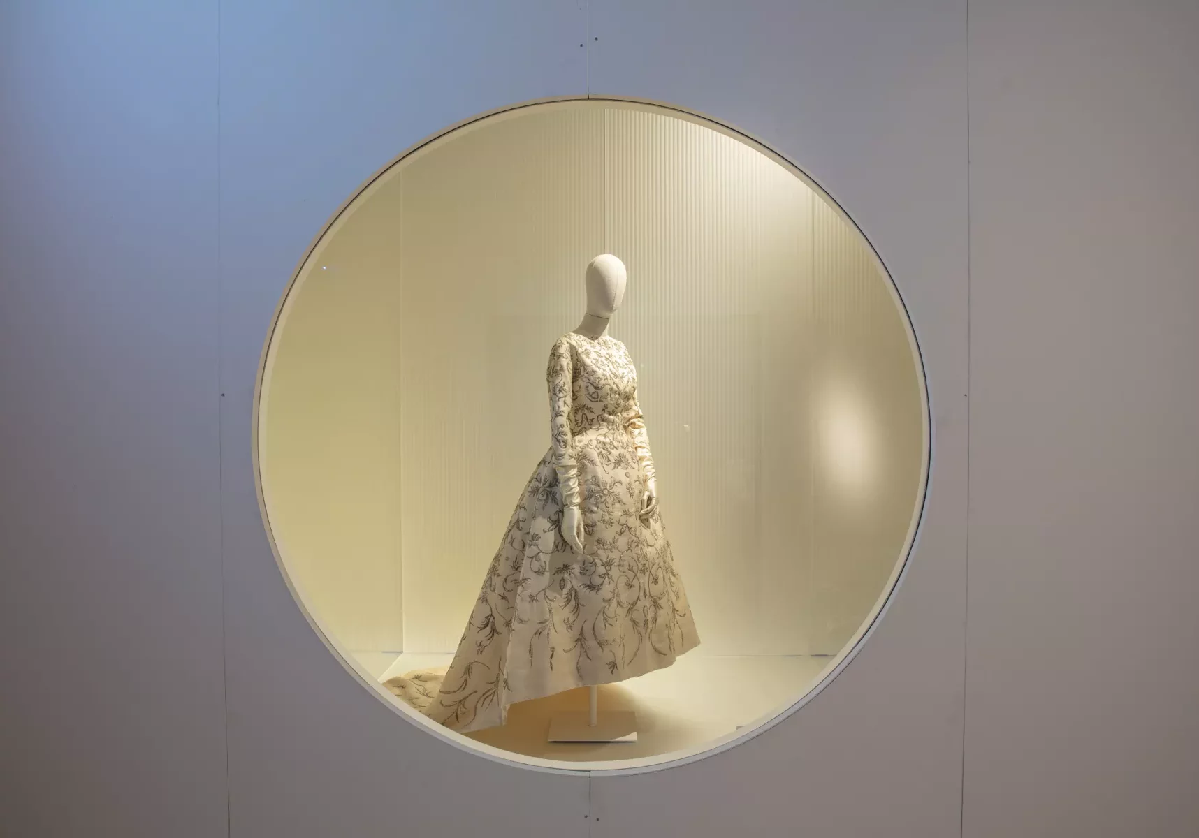 a mannequin with a cream Balenciaga dress staged in a round window