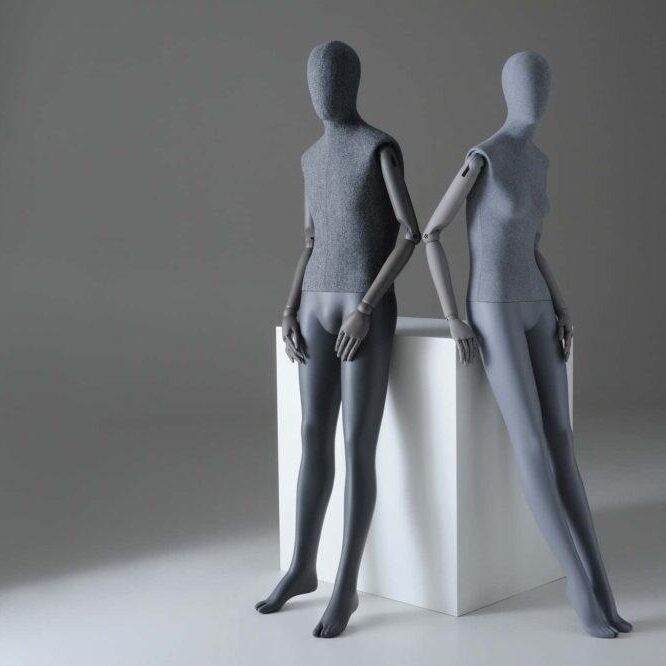 Male and female Sartorial mannequins leaning against a plinth
