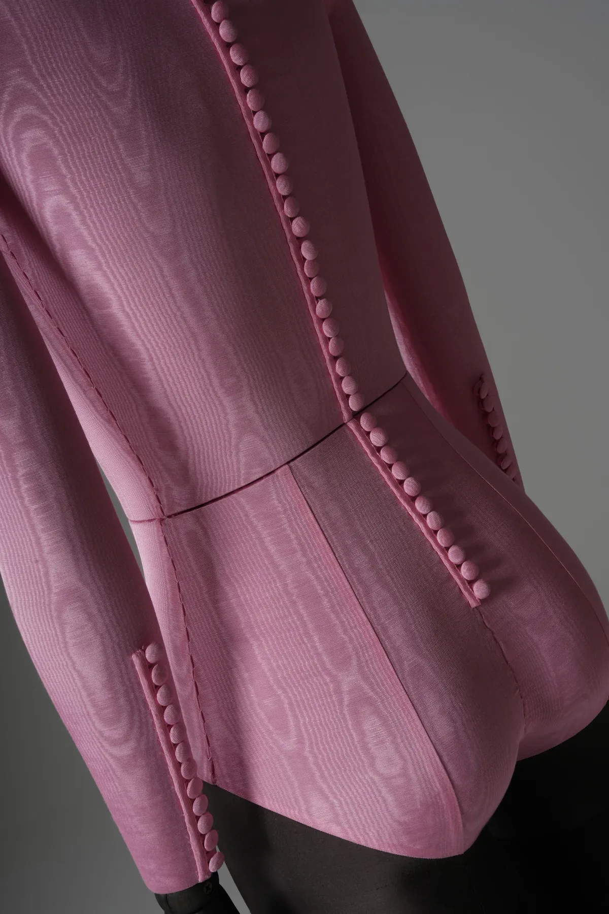 Rear detail of the pink moire bodysuit bespoke mannequin showing covered button closure running down the spine and waistline