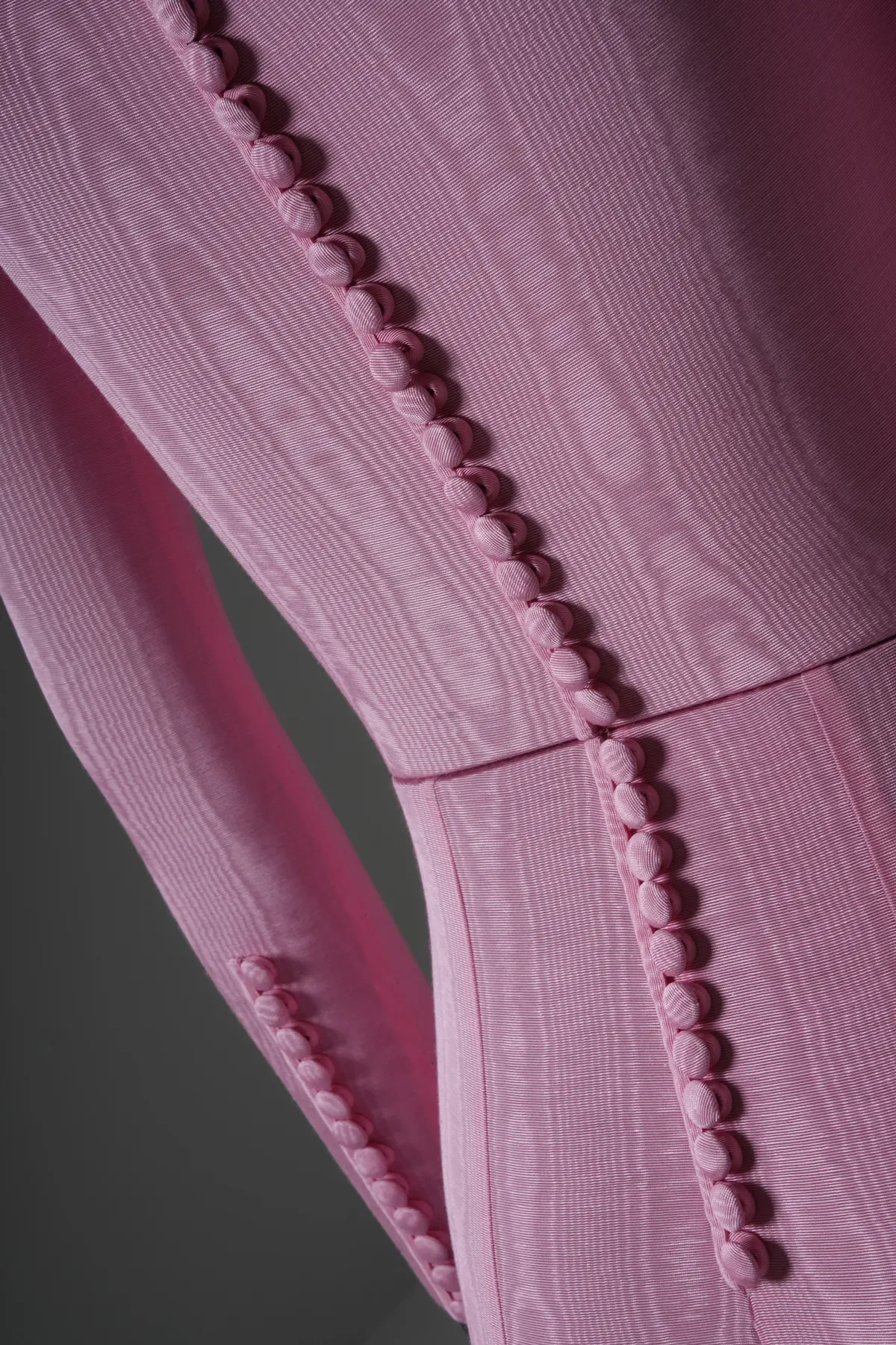 Macro close-up of the covered button and seam detail on the pink moire bodysuit bespoke mannequin
