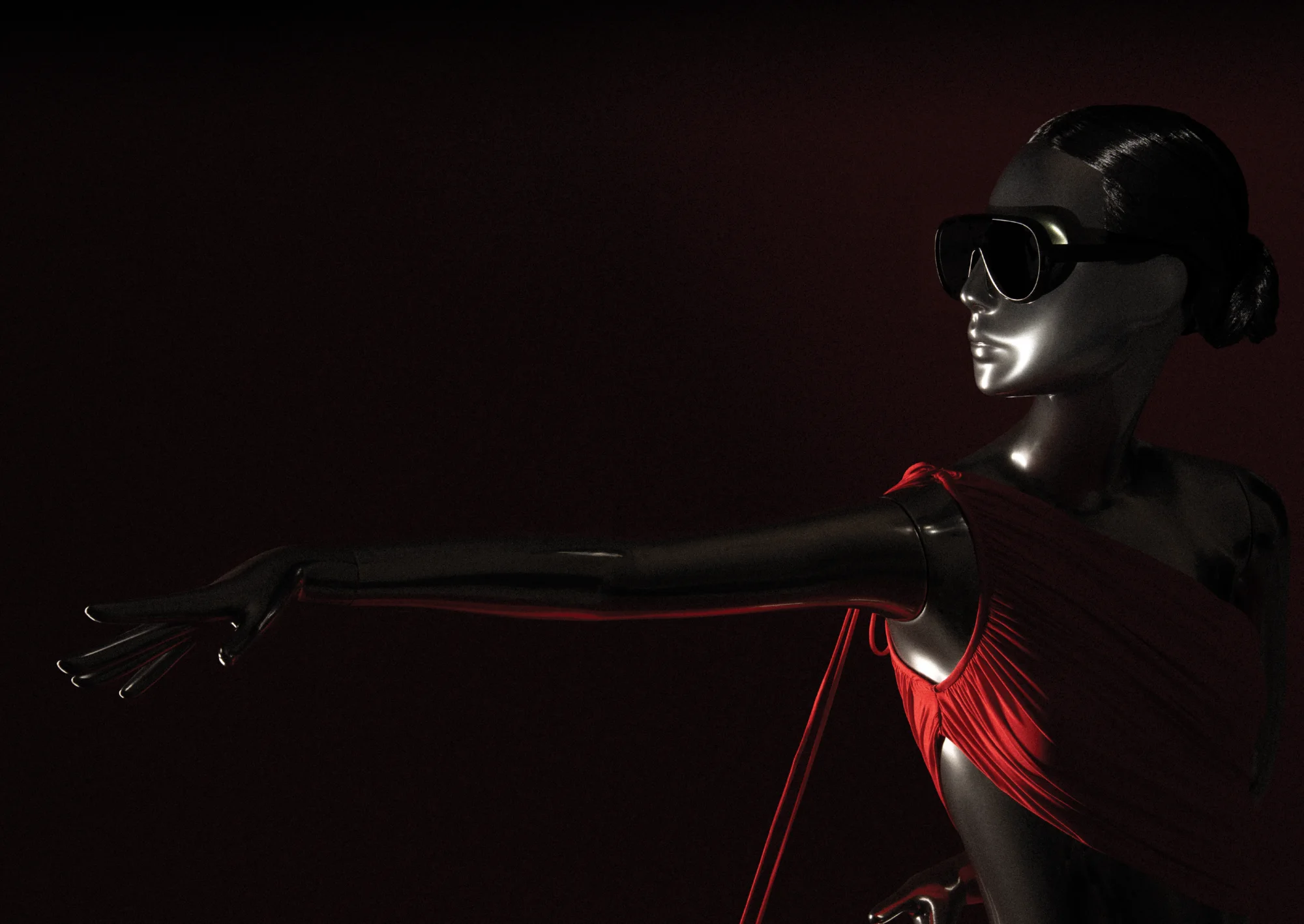 Chrome Obsession mannequin in a red Halston-inspired dress, arm outstretched