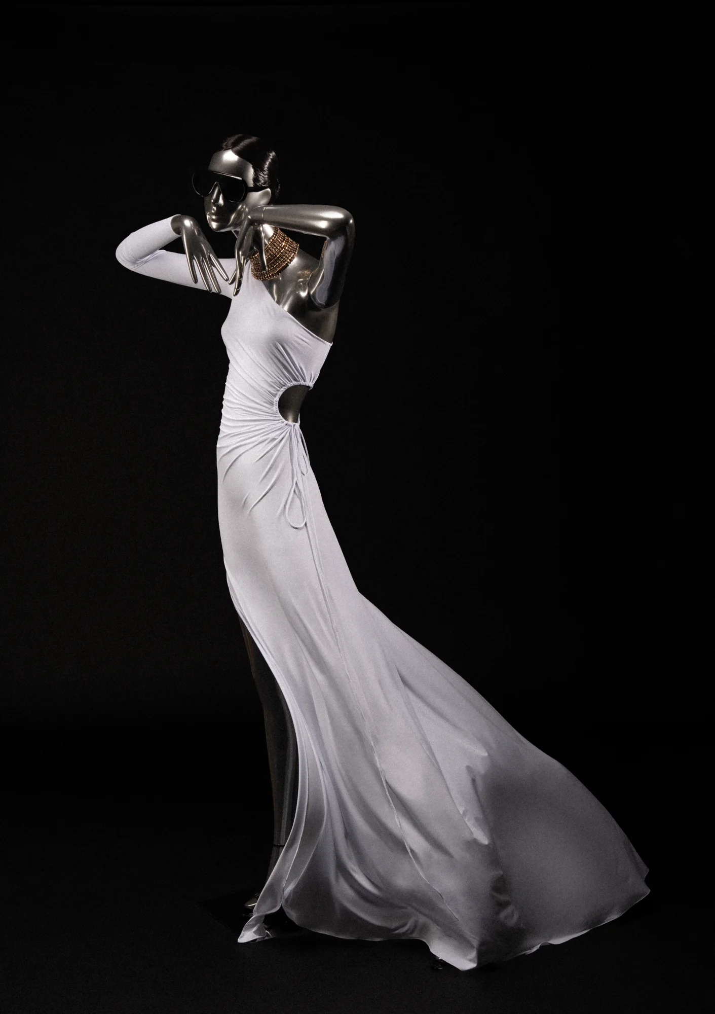 Chrome Obsession mannequin in a flowing white gown against black