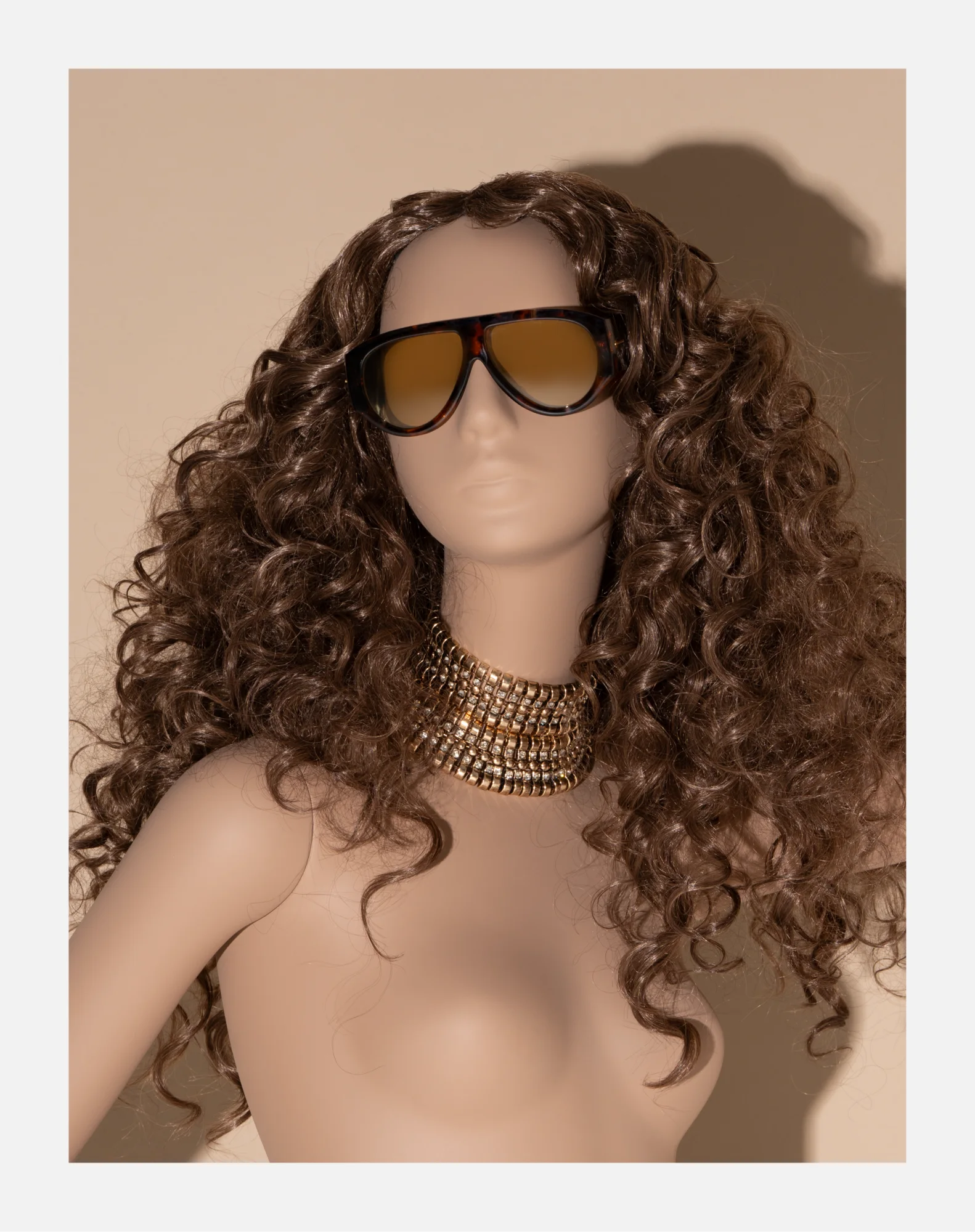 Obsession mannequin in Honey Gold with a brunette Jerry Curl wig, gold collar and sunglasses