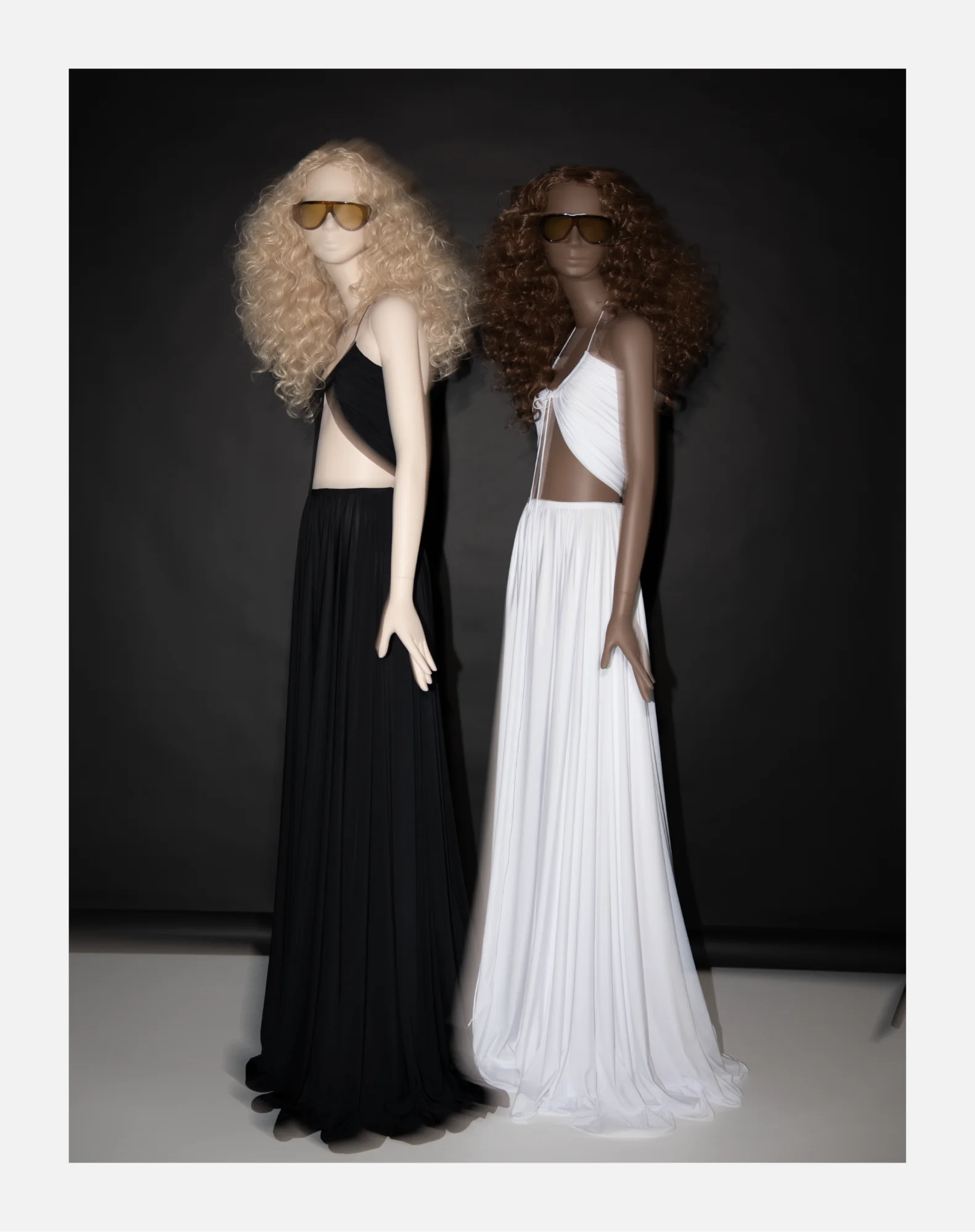 Two Obsession mannequins in black and white Halston-inspired dresses