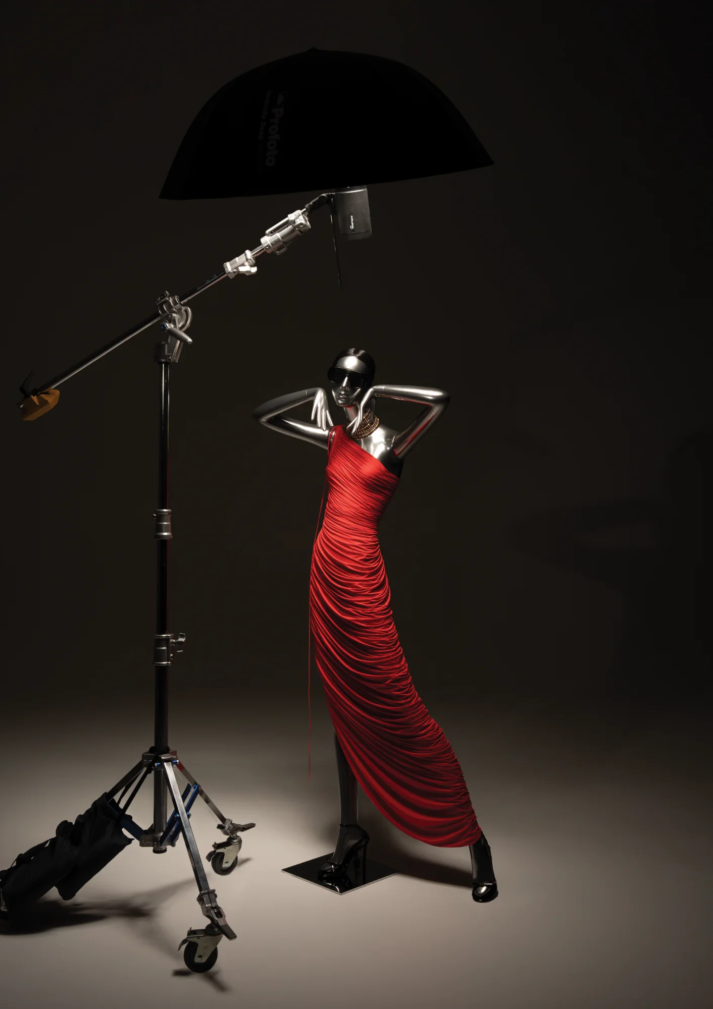 Chrome Obsession mannequin in a red dress under a studio light