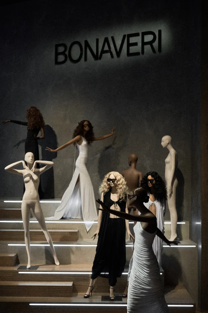 Mannequins in white and black gowns posed on lit steps beneath the Bonaveri sign