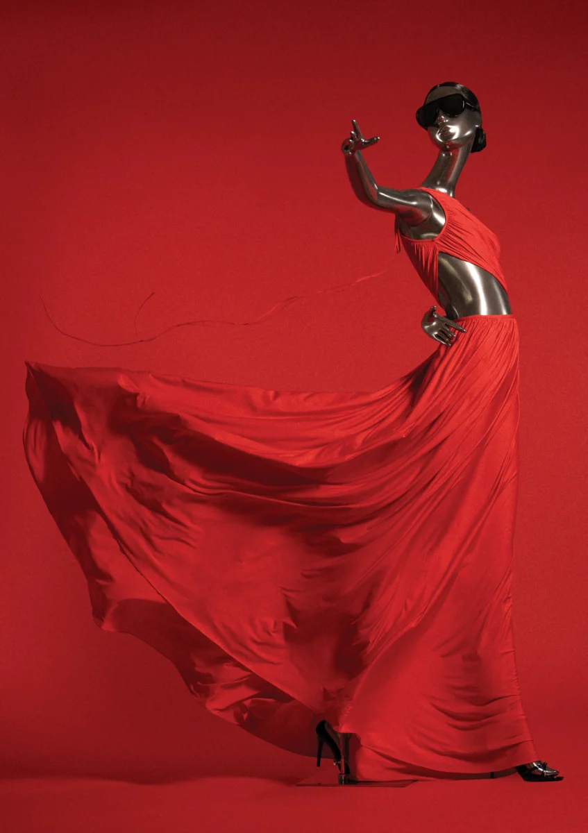 Mannequin in a flowing red dress against a red background: view the campaign